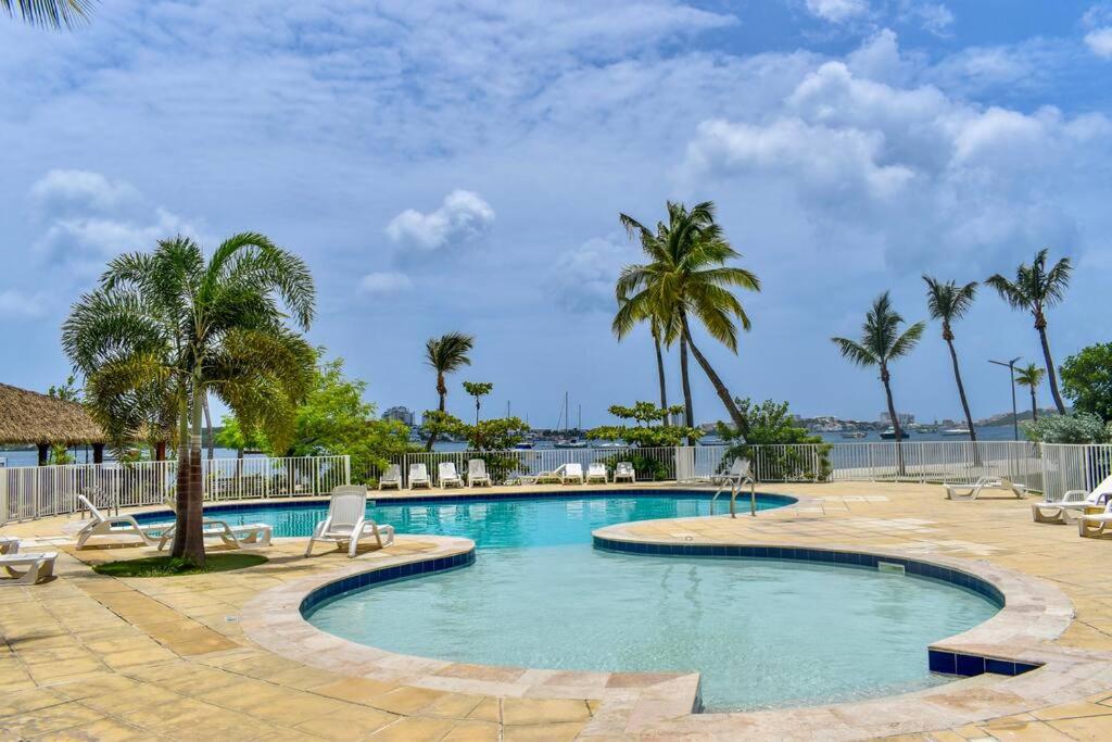 a large swimming pool with palm trees and chairs at Appartement Seacret in Baie Nettle