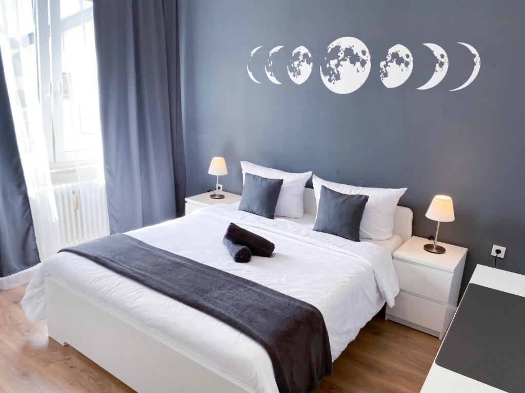 a bedroom with a large white bed with blue walls at NOVA Apartment- Phantasialand I Köln I Bonn in Brühl