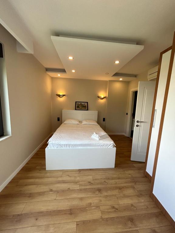 1 dormitorio con cama blanca y suelo de madera en 3 min to beach, luxury building en Antalya