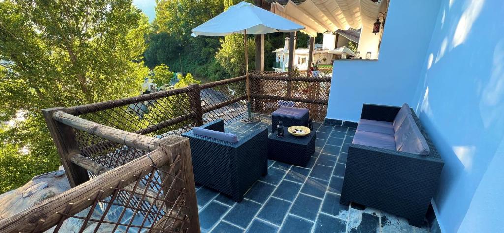 balcón con mesa, sillas y sombrilla en Terraza de Poqueira en Capileira