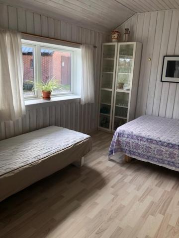 Morsø Friluftscenter في Erslev: غرفة نوم بسريرين ونافذة