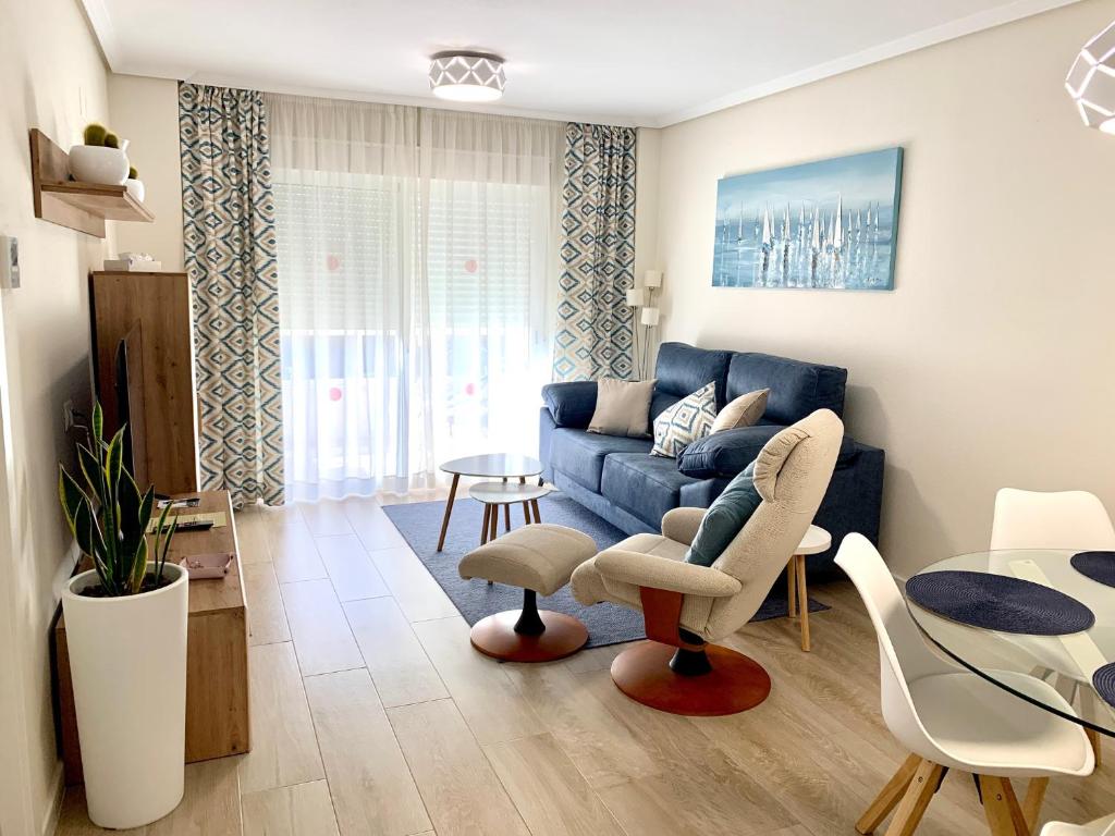 uma sala de estar com um sofá azul e uma mesa em Coliseo Albir Beach em Albir