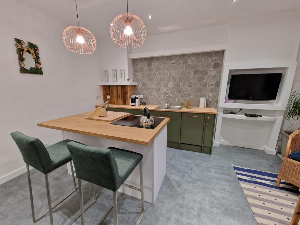 uma cozinha com uma ilha com um lavatório e uma televisão em Apartment Emilia em Świdnica