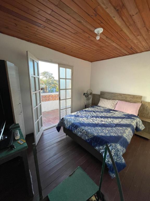 una camera da letto con un letto e una porta scorrevole in vetro di VIRAMAR en Alvorada a Barra del Chuy