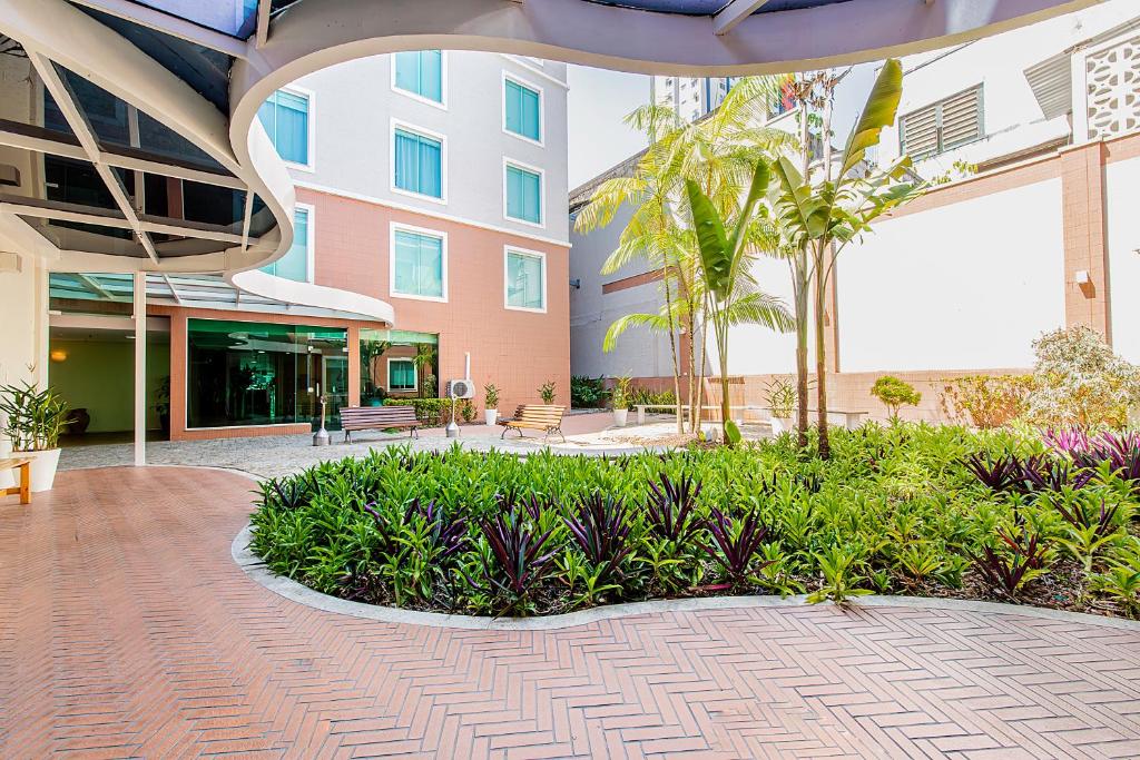 馬瑙斯的住宿－馬瑙斯高旅館，棕榈树和植物的建筑中的庭院