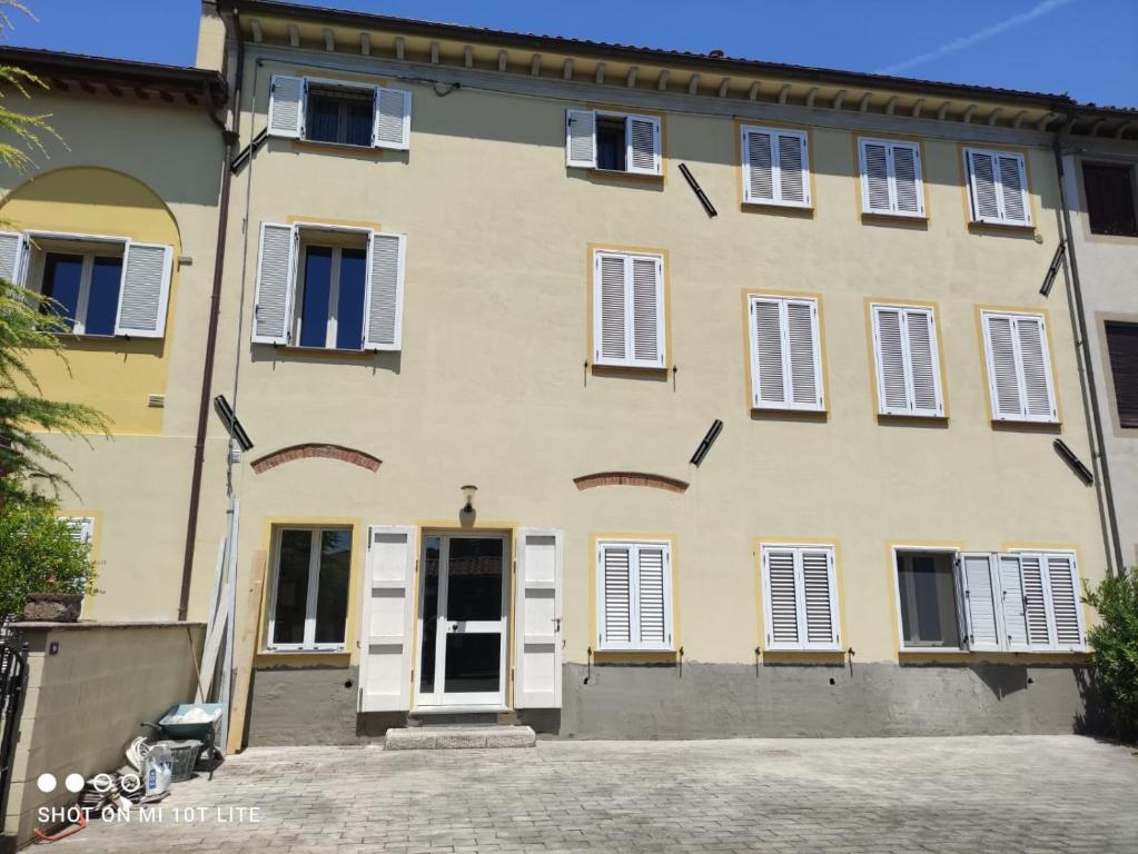 a large building with white doors and windows at Appartamento Il Pozzo in Capannori