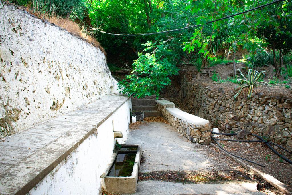 a stone wall with a bench next to a wall at Rias's Place in Kalamiós