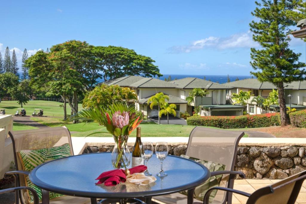 a blue table with a vase of flowers on a patio at K B M Resorts- KGV-25P6 Breathtaking 2Bd remodeled villa, ocean and golf fairway views in Kapalua