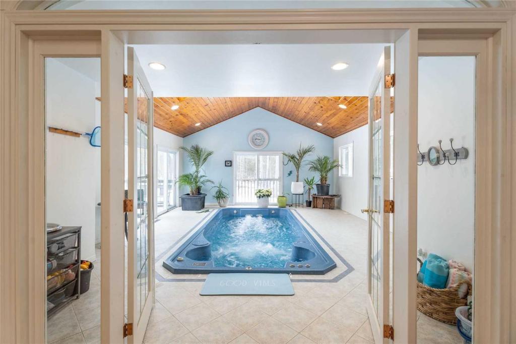 una gran piscina en el medio de una habitación en Casa Borealis - Hot Tub - Fire Pit - BBQ, en Orillia
