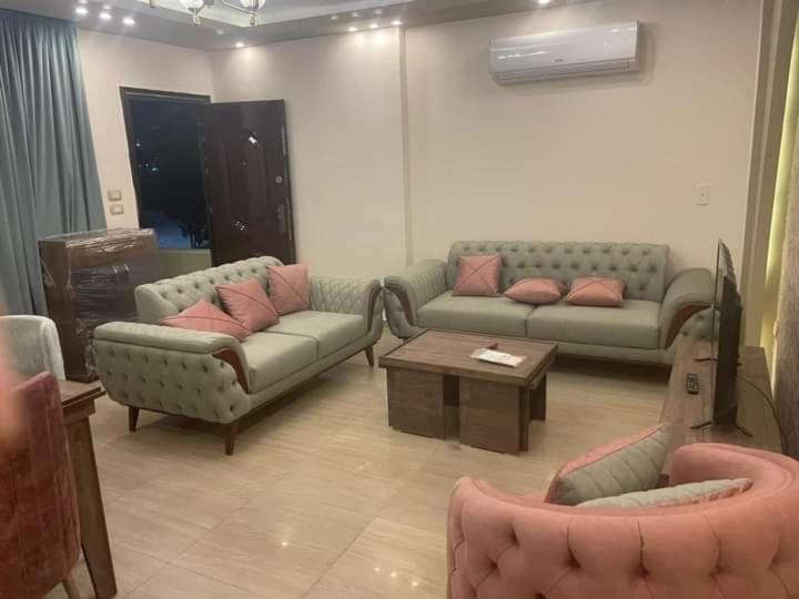 ein Wohnzimmer mit 2 Sofas und einem Tisch in der Unterkunft شقق مفروشه in Madinat as-Sadis min Uktubar