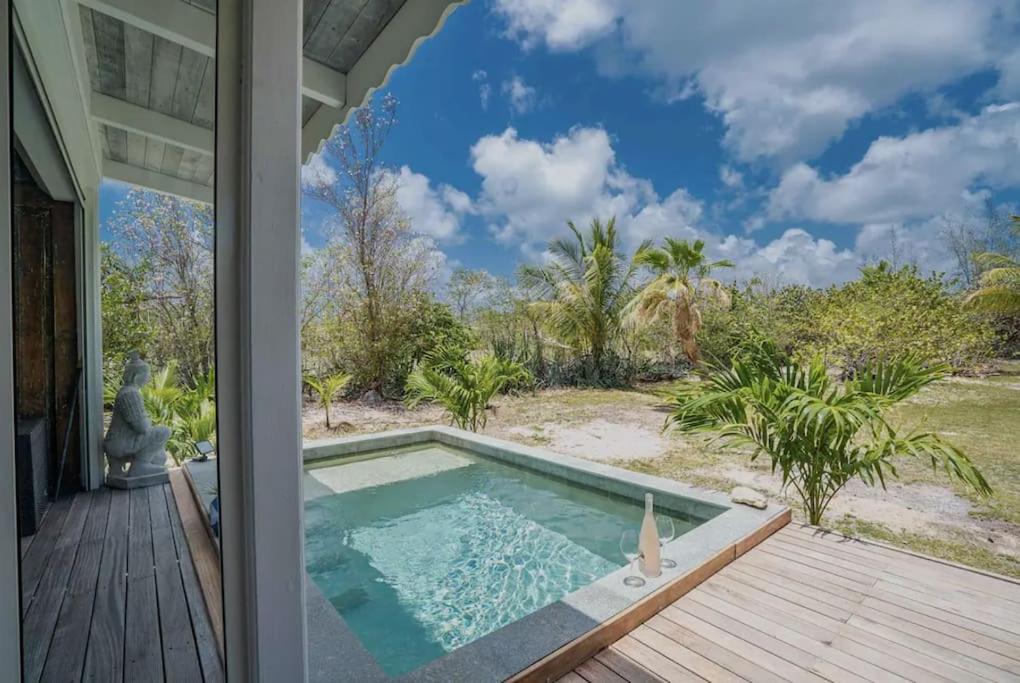 - une piscine sur une terrasse à côté d'une maison dans l'établissement Cottage Saudade - Les Terres Basses, à Marigot
