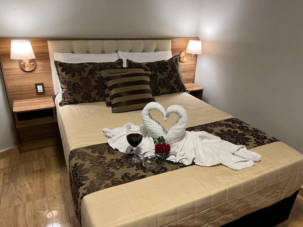 um quarto com uma cama com dois cisnes em Pousada Serra Geral em Cambará