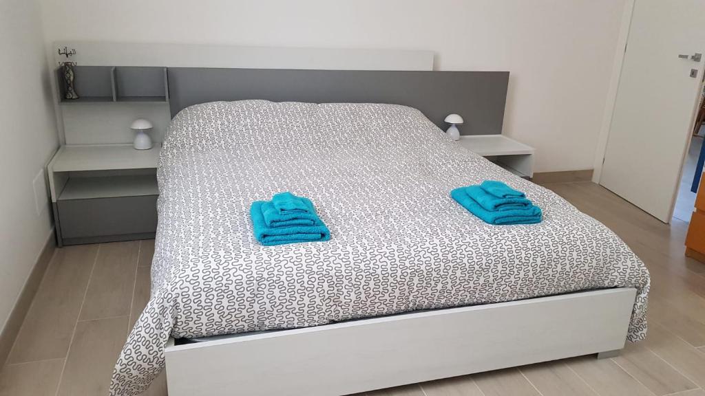 a bedroom with a bed with blue towels on it at Seveso appartamento nuovo tra Milano, Monza e Como in Seveso