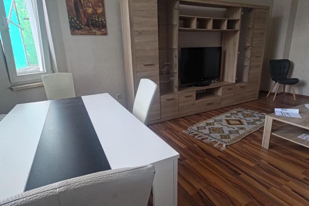 a living room with a table and a flat screen tv at 60qm-Wohnung im 2. OG mit Balkon in Duisburg