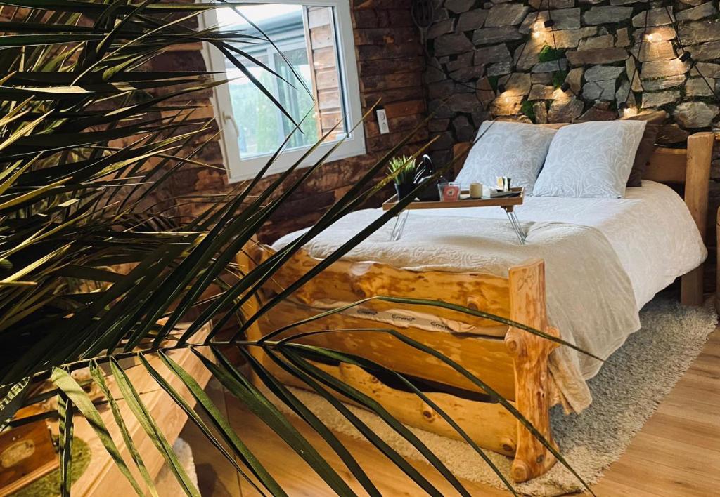 1 dormitorio con cama y pared de piedra en Un havre de quiétude au cœur des Montagnes en Métabief