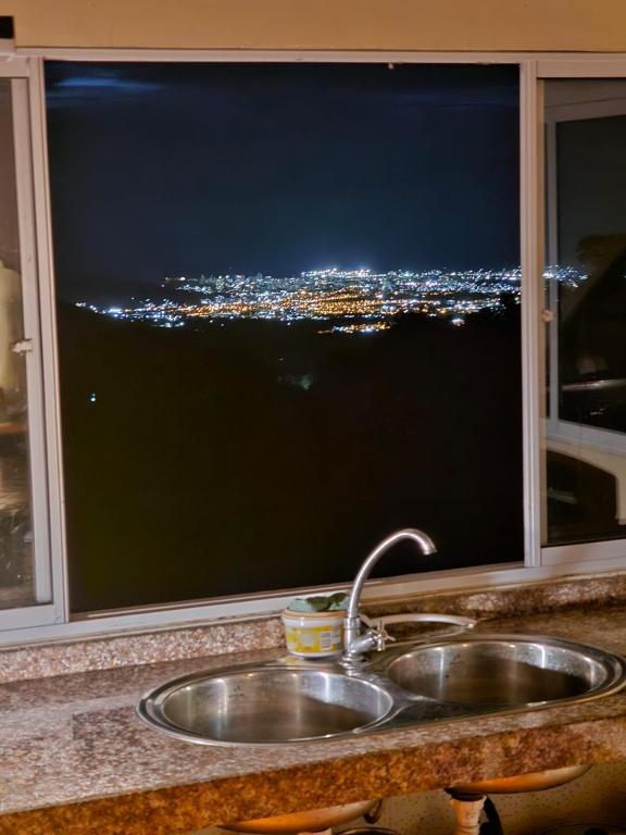a kitchen sink with a view of a city from a window at Cabaña Mountain Ocean View Minca in Minca