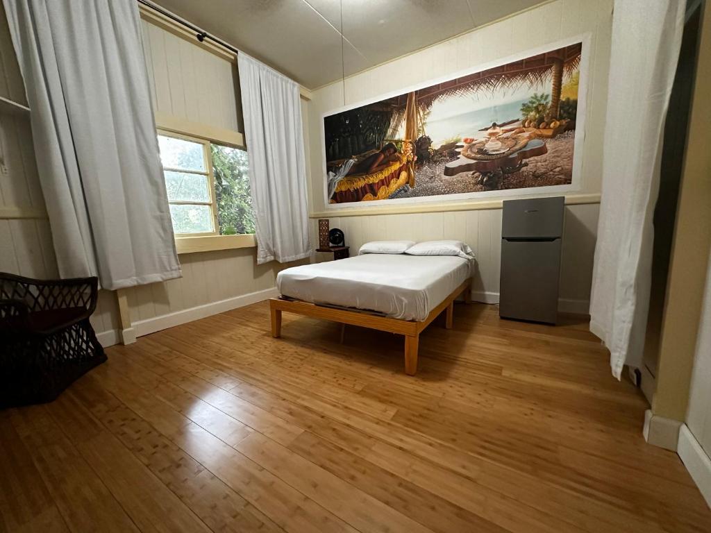 Wild Ginger Hotel في هيلو: غرفة نوم بسرير ودهان على الحائط