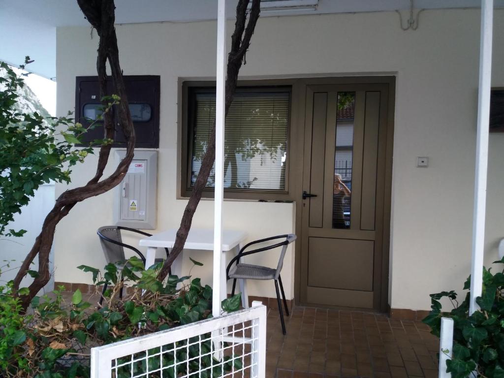 a table and chairs in front of a house at Apartman - Sutomore in Sutomore
