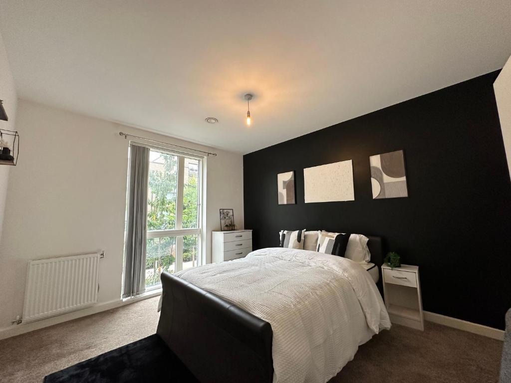 a bedroom with a black accent wall and a bed at Deluxe Spacious Room Near London Bridge! in London