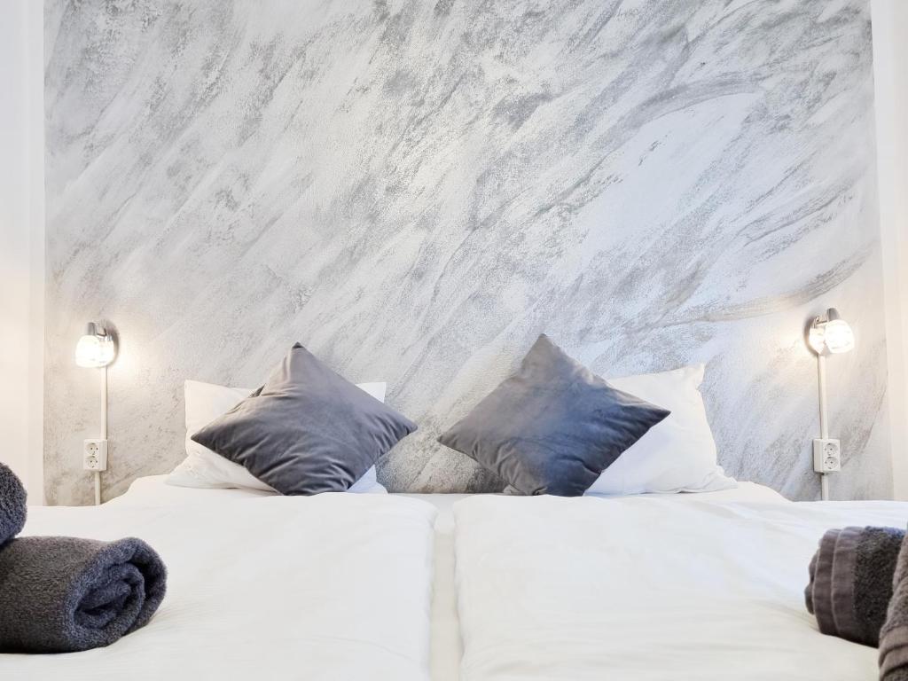 a bedroom with a white bed with blue pillows at Da Vinci Apartment in Kapfenberg