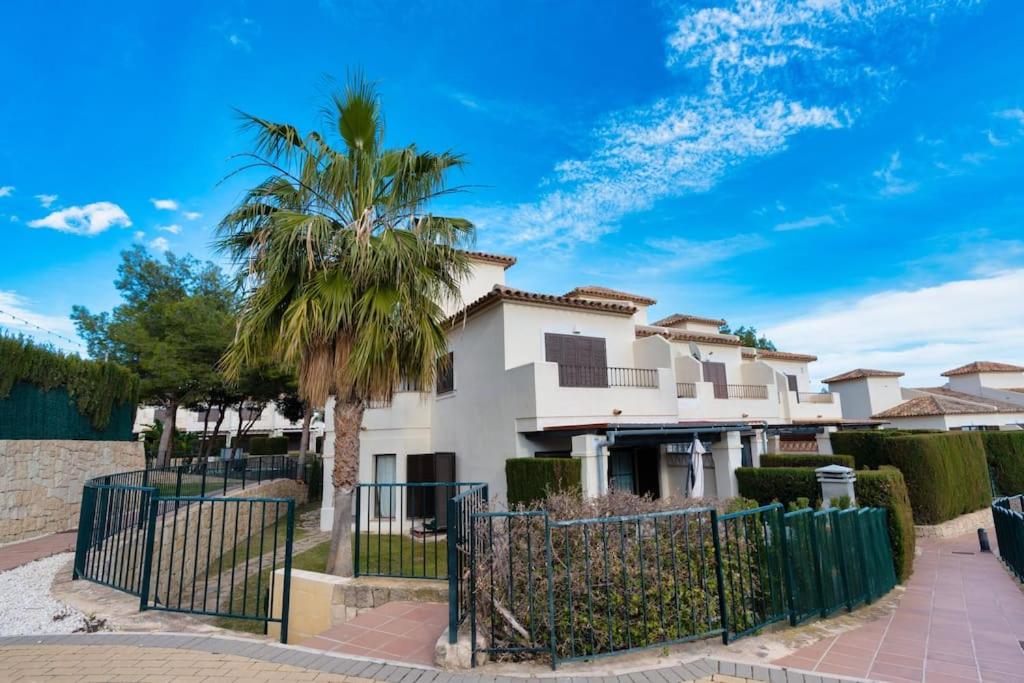 una casa con una valla y una palmera en Villa Lux Finestrat, en Finestrat