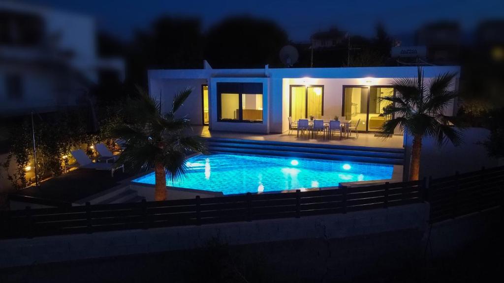 a swimming pool in front of a house at night at Kyamon Estate Luxury Villa in Galangádhos