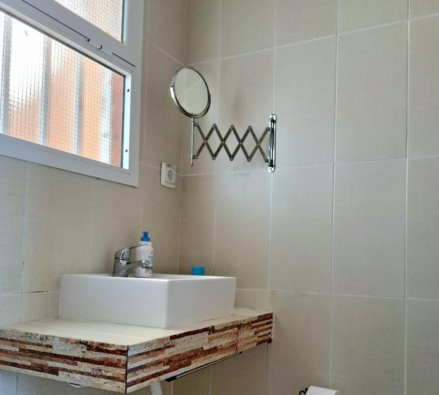 uma casa de banho com um lavatório branco e um espelho. em Casa da Mata em Populo