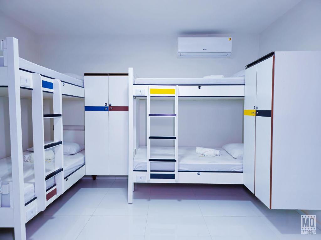 a room with three bunk beds and a ladder at MANERO HOSTEL e POUSADA in Natal