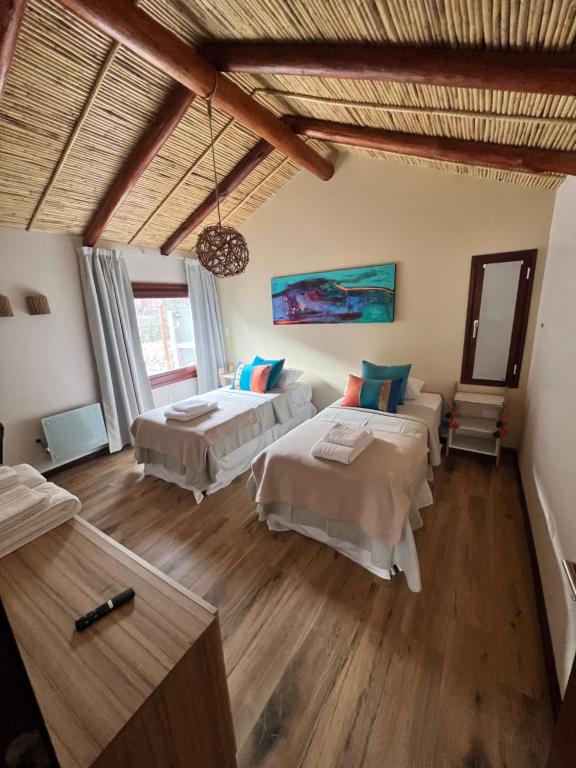 a bedroom with two beds and a wooden floor at Pucara Lodge 1D in Tilcara