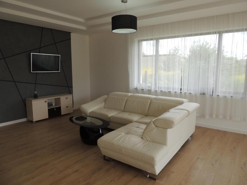 a living room with a white couch and a tv at New House White near Targi Kielce in Kielce