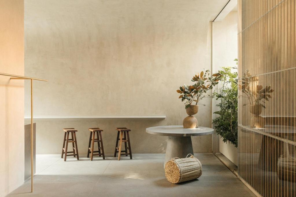 um quarto com bancos e uma mesa com um vaso em Octavia Casa em Cidade do México
