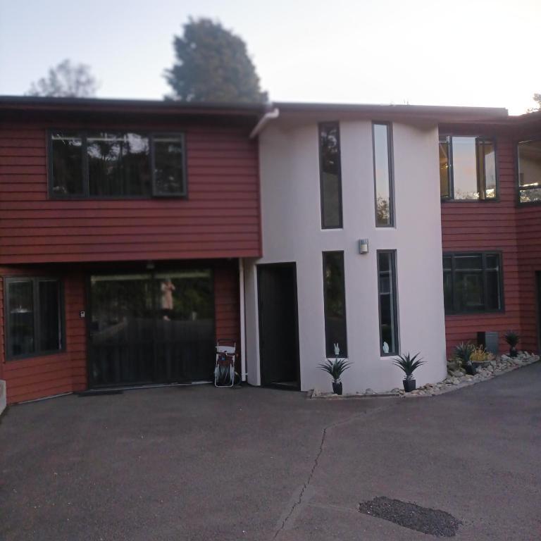 Casa roja y blanca con entrada en Tiwai Waka Retreat en Wellington