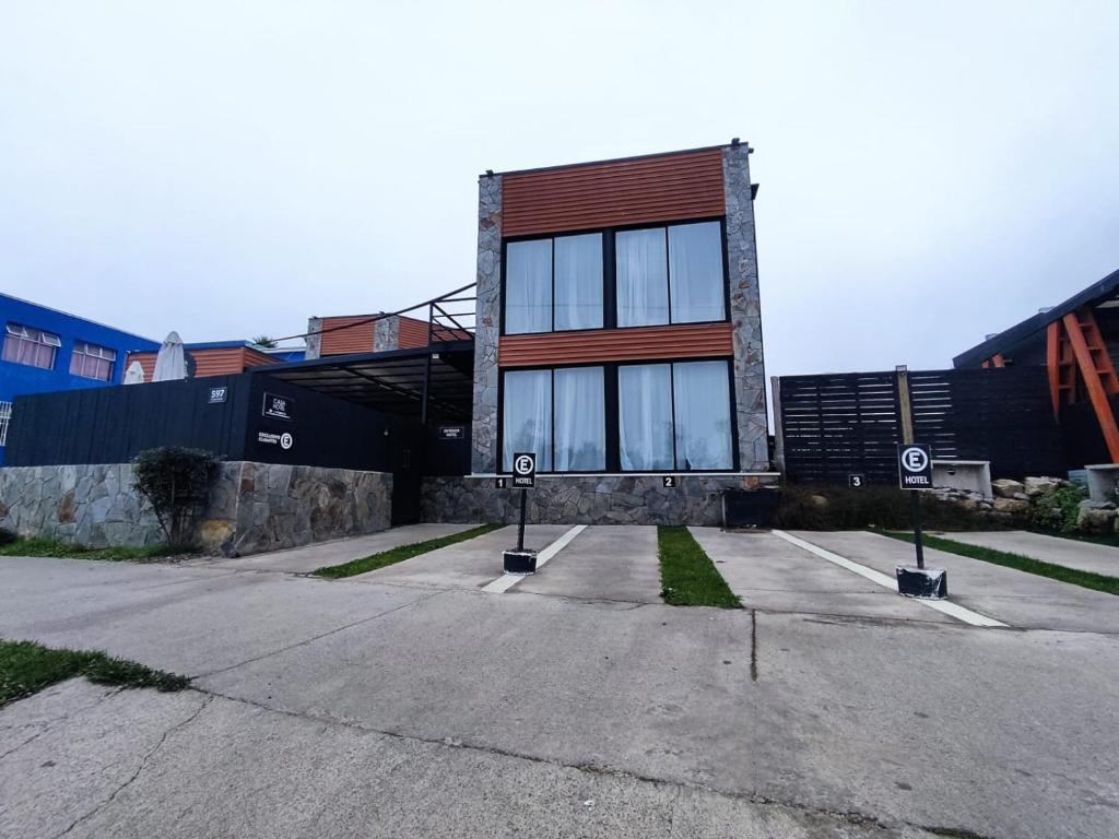 un edificio con muchas ventanas en un estacionamiento en Casa Hotel Trocha Angosta en Constitución