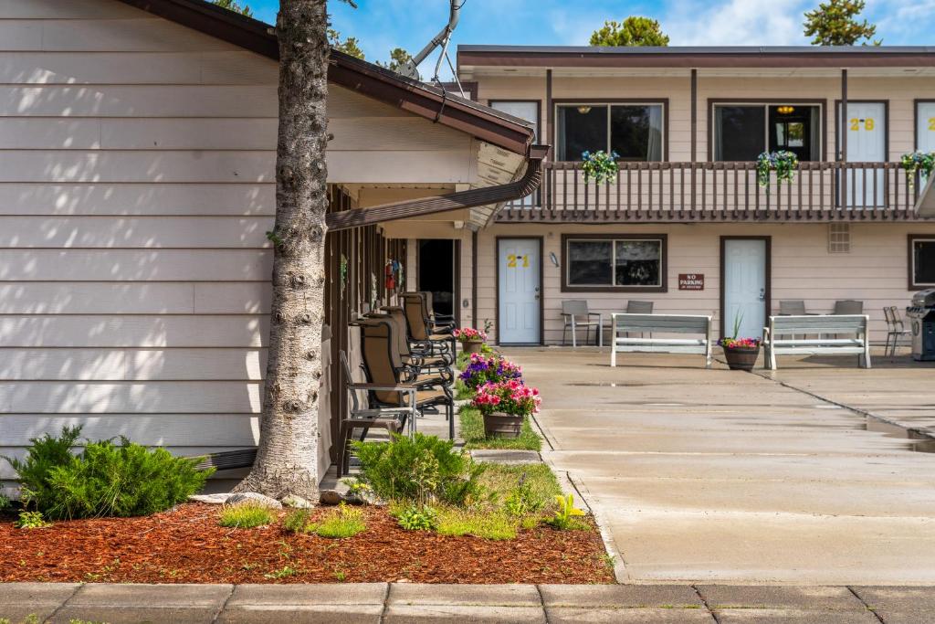 una casa con portico con sedie e fiori di Lazy Duck Inn a West Yellowstone