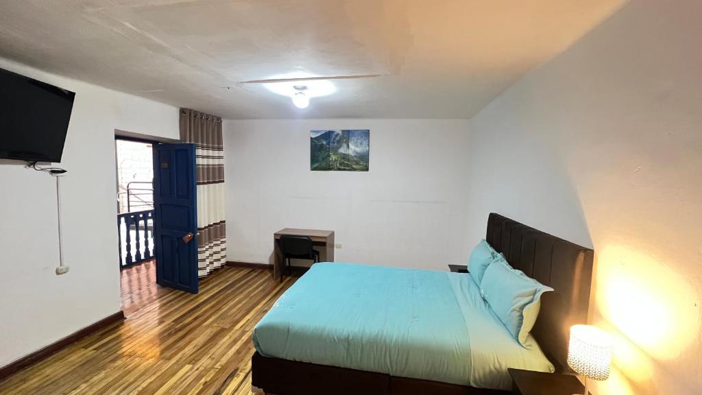 sypialnia z łóżkiem i telewizorem w obiekcie Valicha Casa Hotel w Cuzco