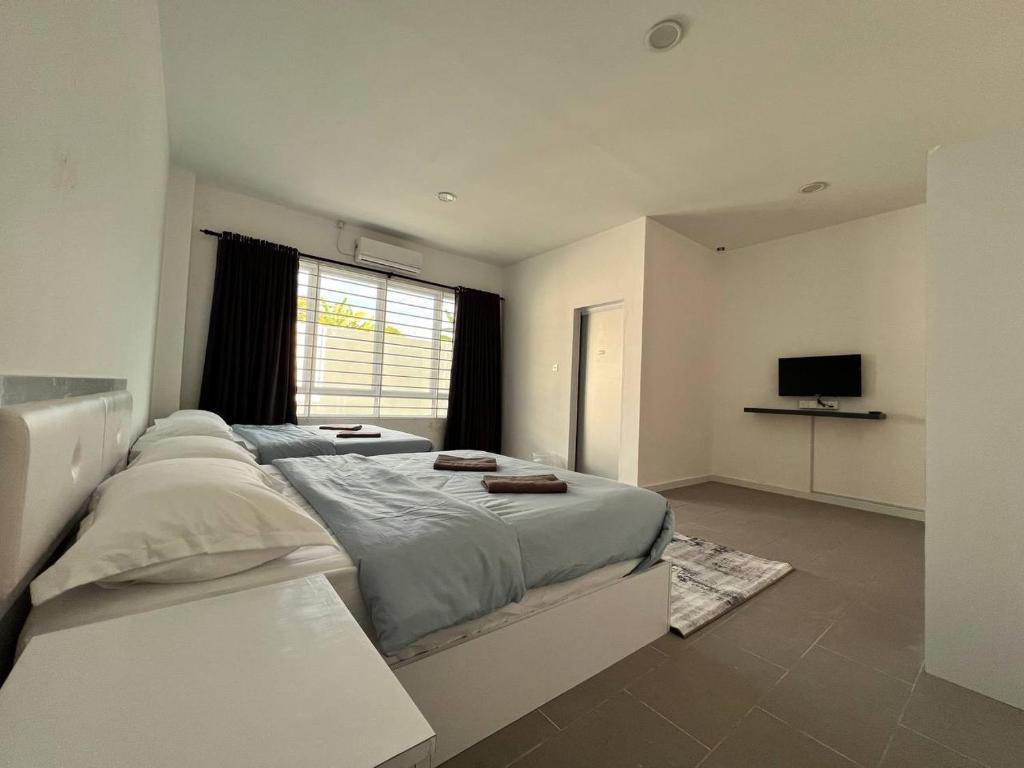 1 dormitorio con 1 cama grande y TV en IJ Lodge, en Miri