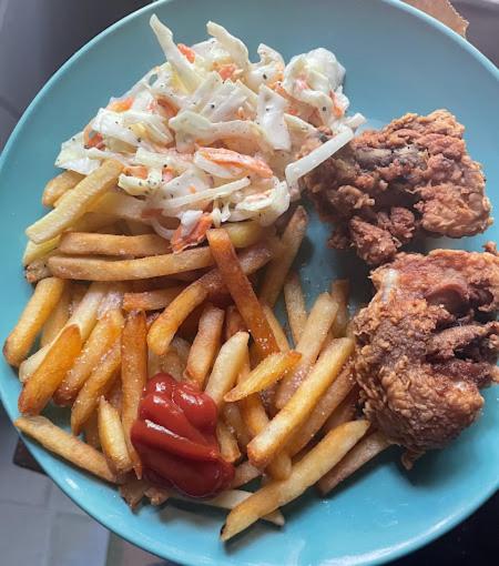 a blue plate with french fries and a side of food at Airport Inn Roatan in Coxen Hole