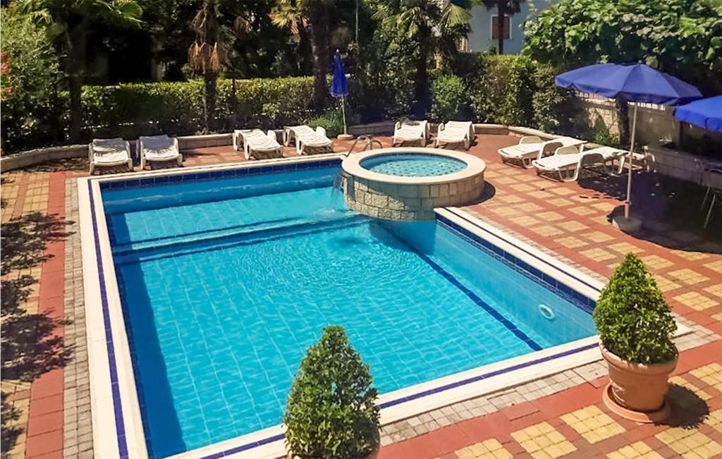 an empty swimming pool with chairs and umbrellas at 1 Bedroom Cozy Apartment In Kukci in Kukci