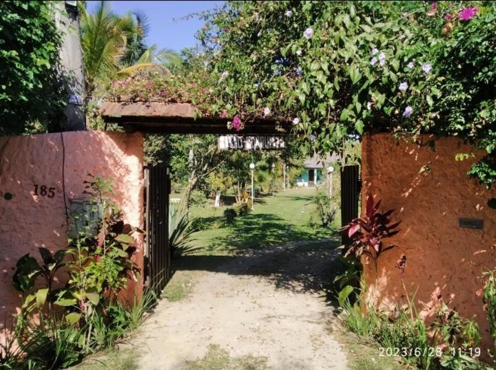 een ingang naar een huis met een boog met bloemen bij SÍTIO CONQUISTA FELIZ in Nova Iguaçu