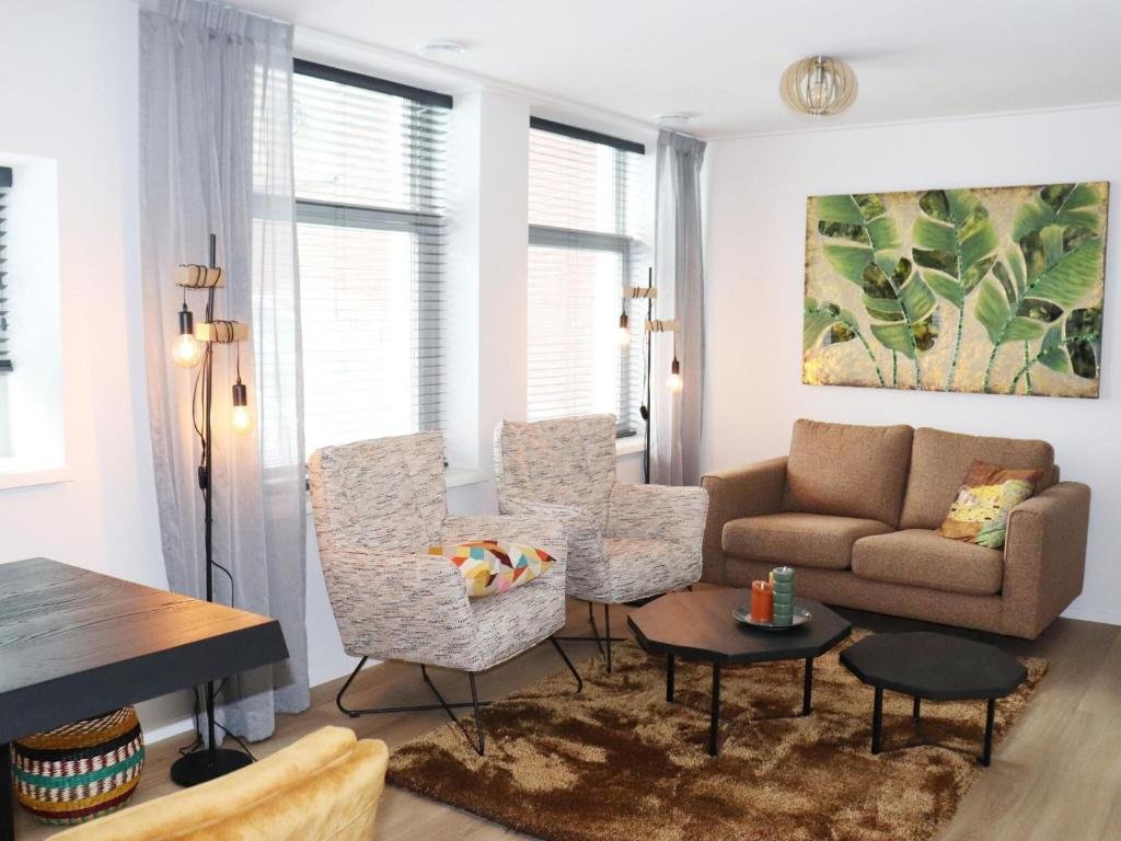 a living room with a couch and chairs and a table at 2 modern apartments in the heart of Sneek in Sneek