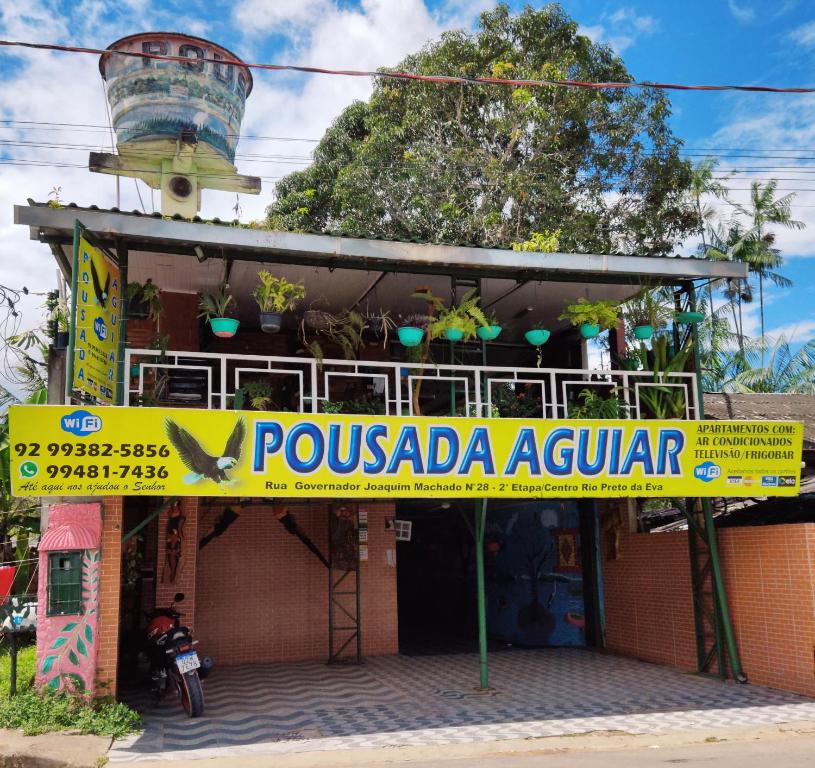 um edifício com um sinal amarelo que diz rovezza azaran em Pousada Aguiar em Rio Preto Da Eva