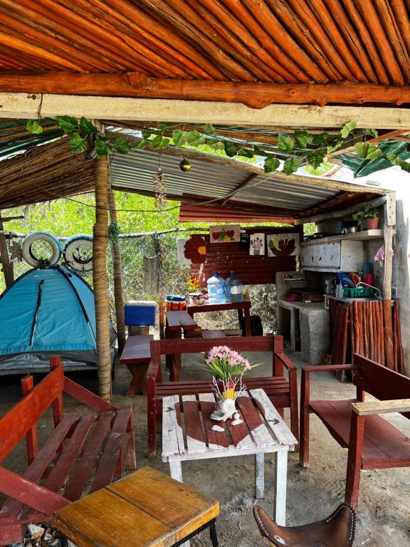 un grupo de mesas y sillas bajo una tienda en Casa de los Santos Camping y eco cabañas en Holbox Island
