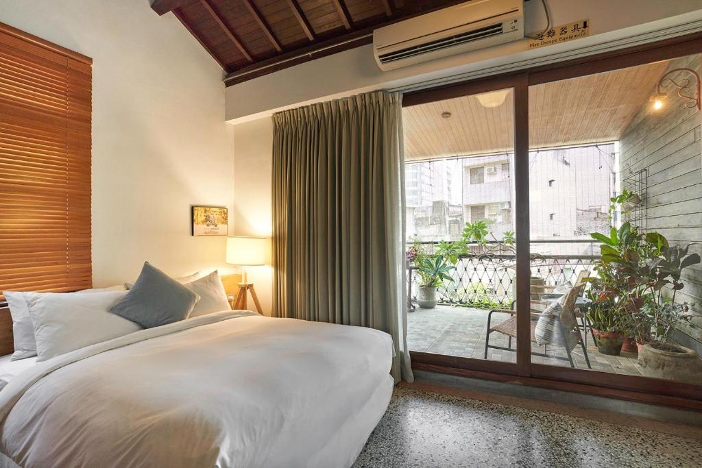 台南的住宿－來了，一间卧室设有一张床和一个大窗户