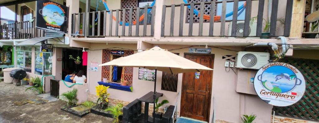 an umbrella sitting in front of a building at Apartahotel & Gym Rondon in Tortuguero