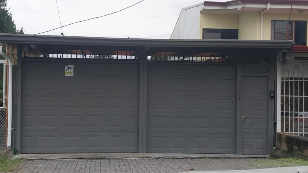 uma porta de garagem em frente a uma casa em Nina´s - Juan Santamaria em Alajuela