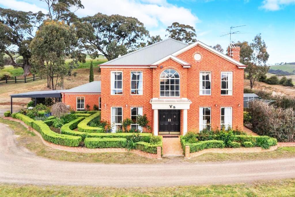 a red brick house with a landscaping at Centelle Park Farm Stay in Kilmore East