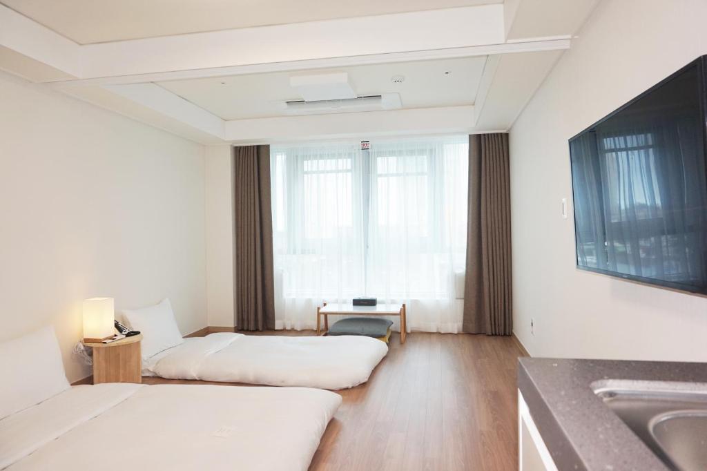 Postel nebo postele na pokoji v ubytování Marinabay Sokcho