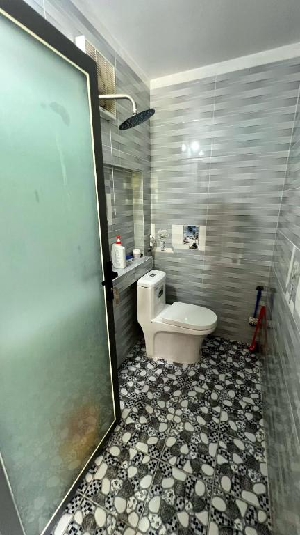 a bathroom with a toilet and a tiled floor at Phu Nam House - Resort in Phú Quốc