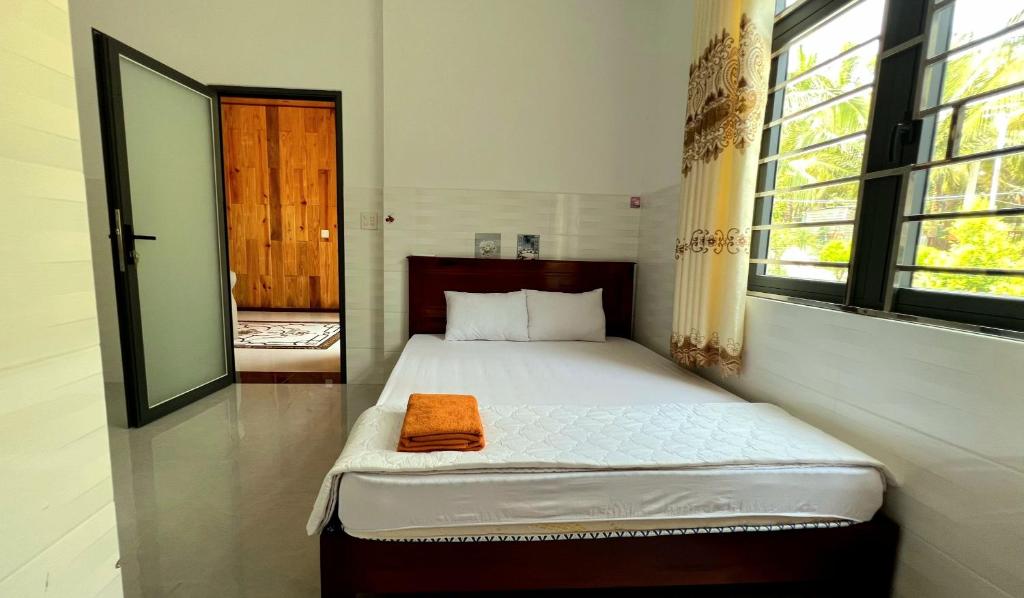 a bedroom with a bed with an orange towel on it at Phu Nam House - Resort in Phú Quốc