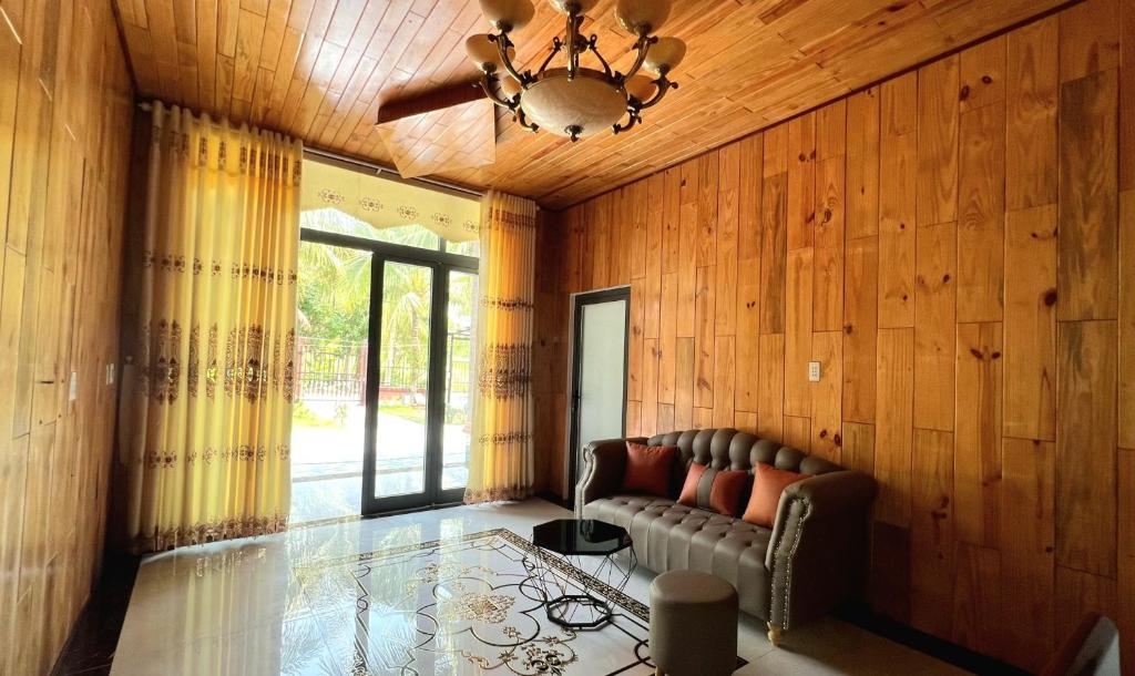 a living room with a couch and a ceiling fan at Phu Nam House - Resort in Phú Quốc